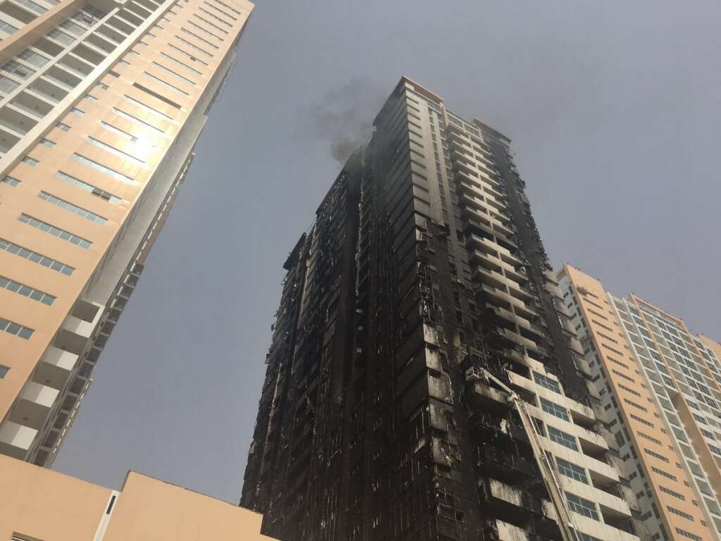 Smoke rises from a damaged residential tower after a fire erupted and burned up the side of several towers.-AP